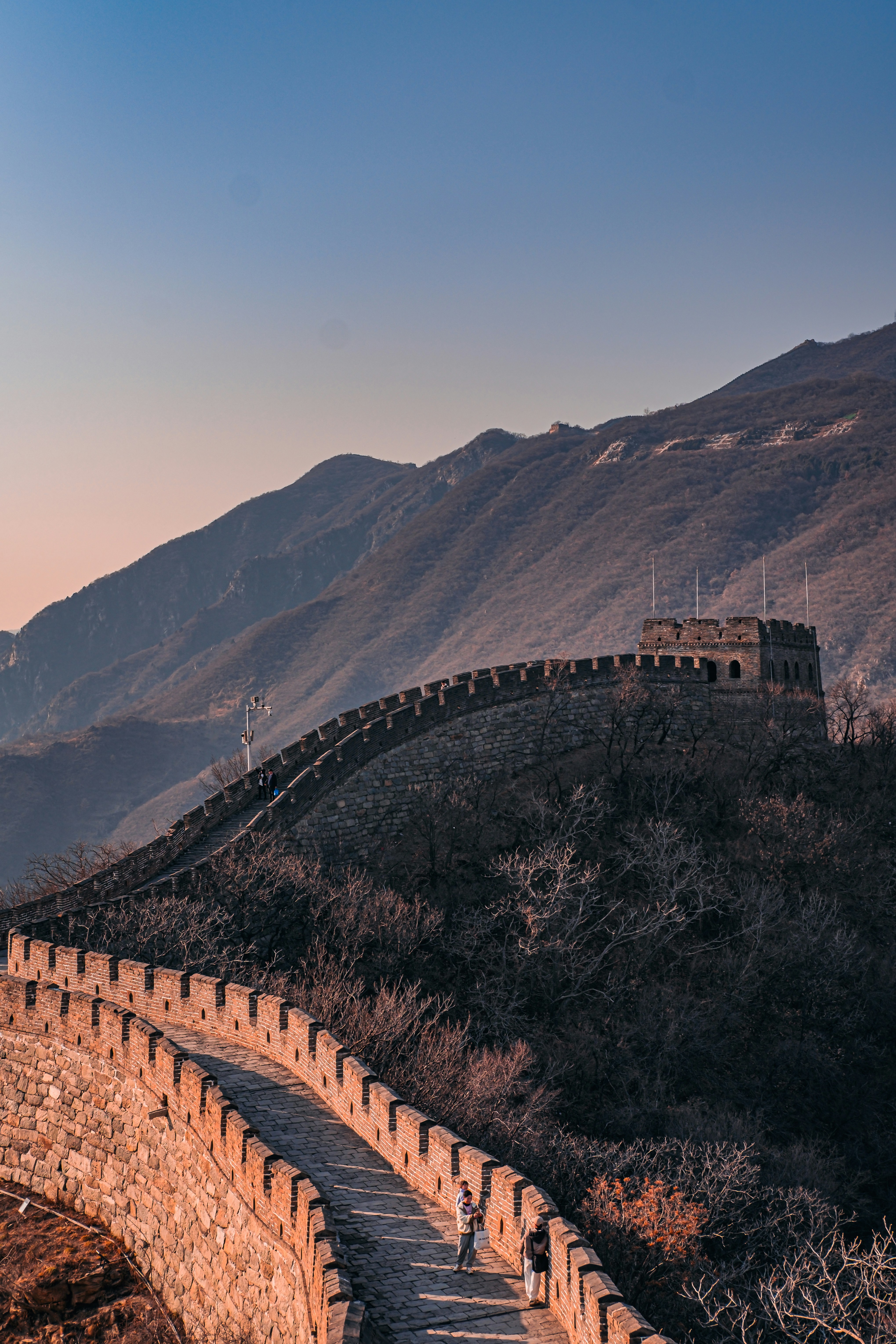 A family walking up the restored steps of the Great Wall at Mutianyu — the most kid-friendly section of the Wall with gentle slopes and a toboggan slide down.