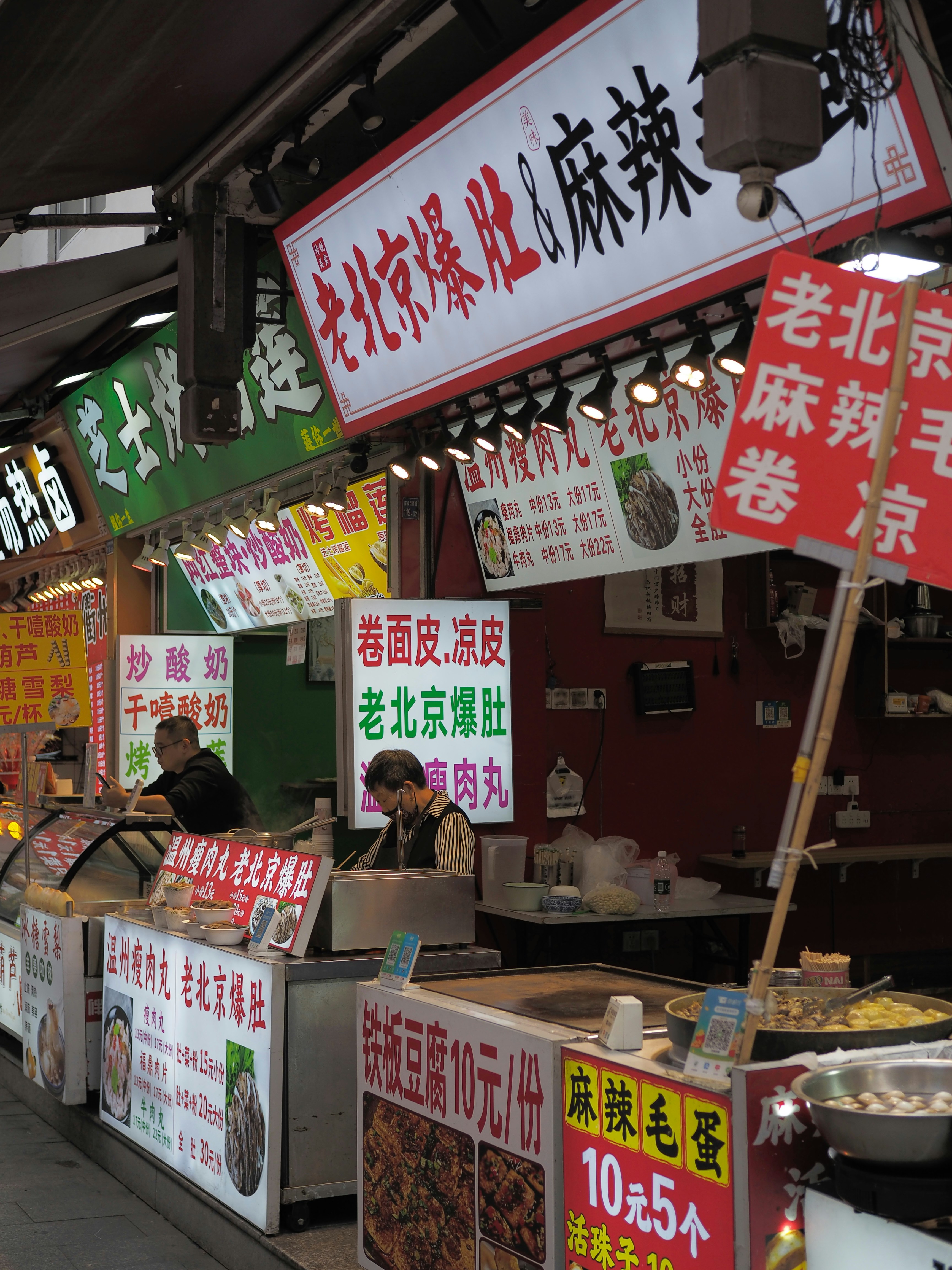 Street food vendor in a Chinese night market — a typical meal costs $3 to $8, the best food-to-cost ratio in Asia.