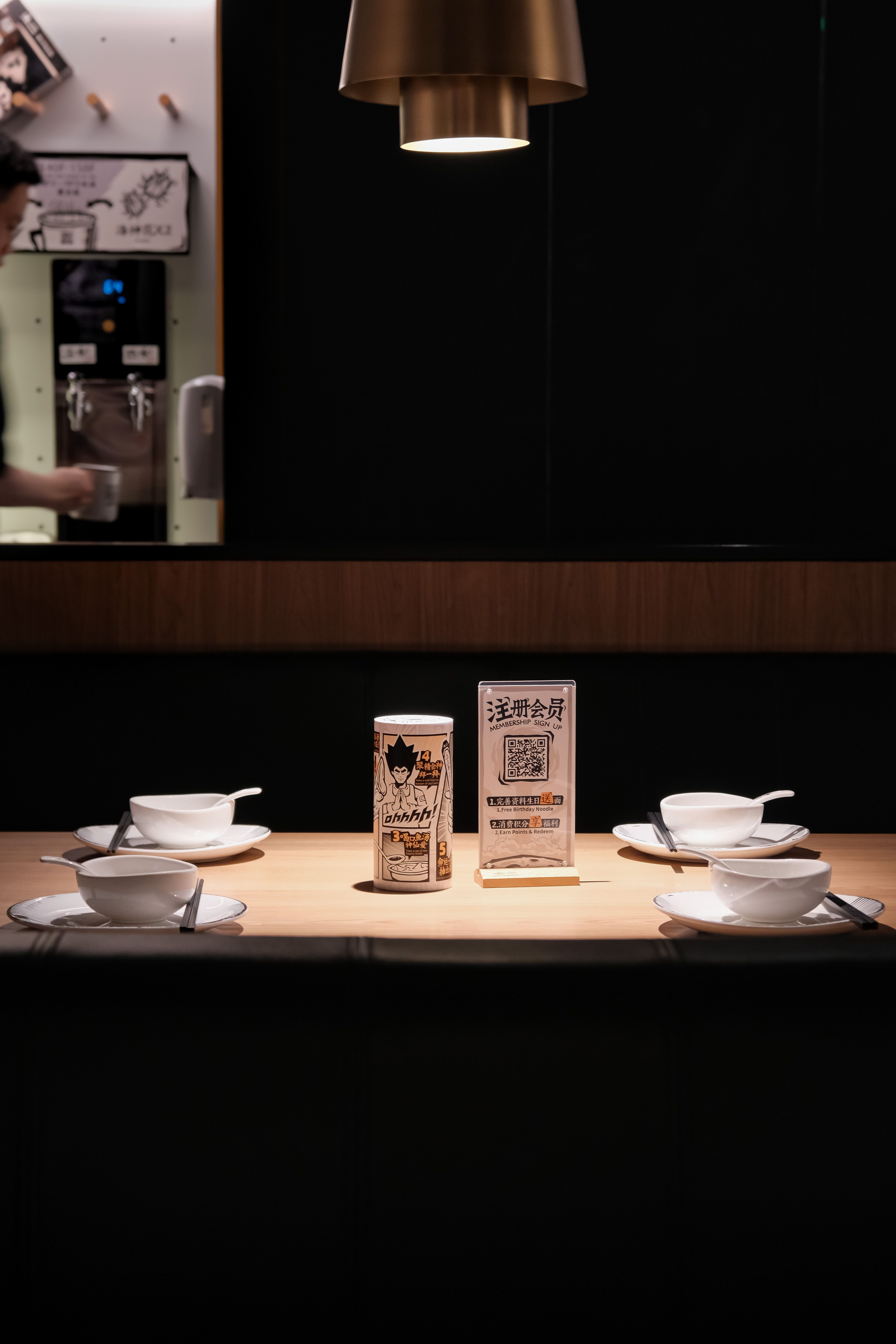A QR code on a Chinese restaurant table linking to a photo-rich ordering system on a smartphone — the standard way to order food in China in 2026.