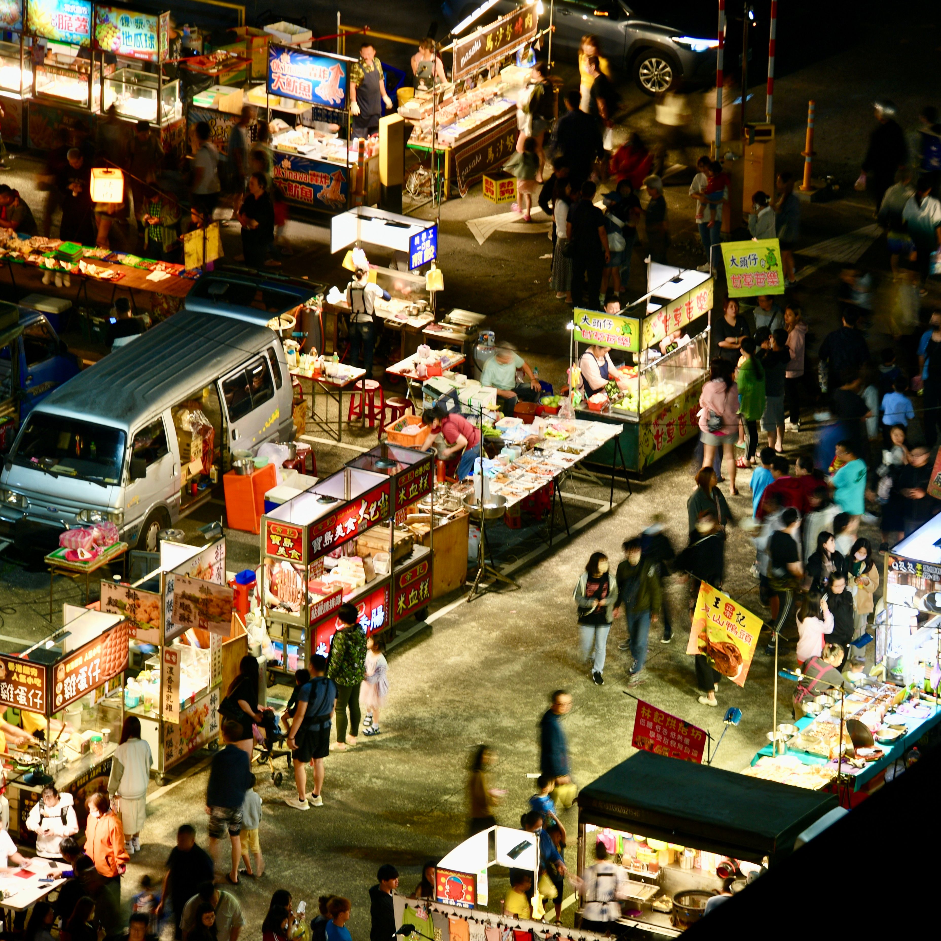A Chinese night market with food stalls selling grilled skewers, dumplings, and street snacks — pick the stall with the longest queue.
