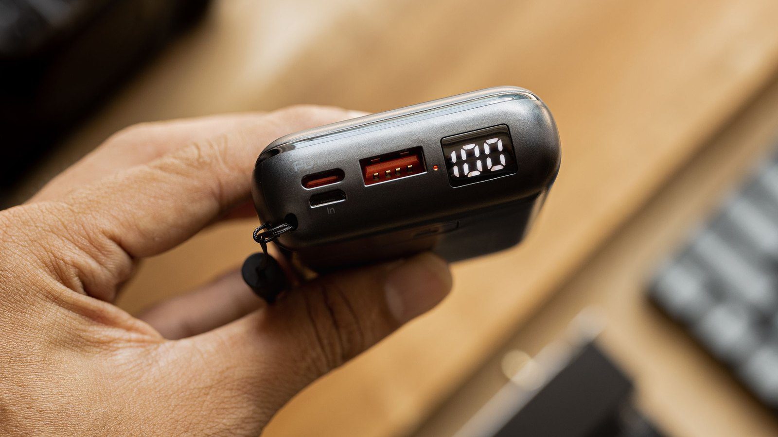 Close-up of a portable power bank showing its ports and 100 percent battery display