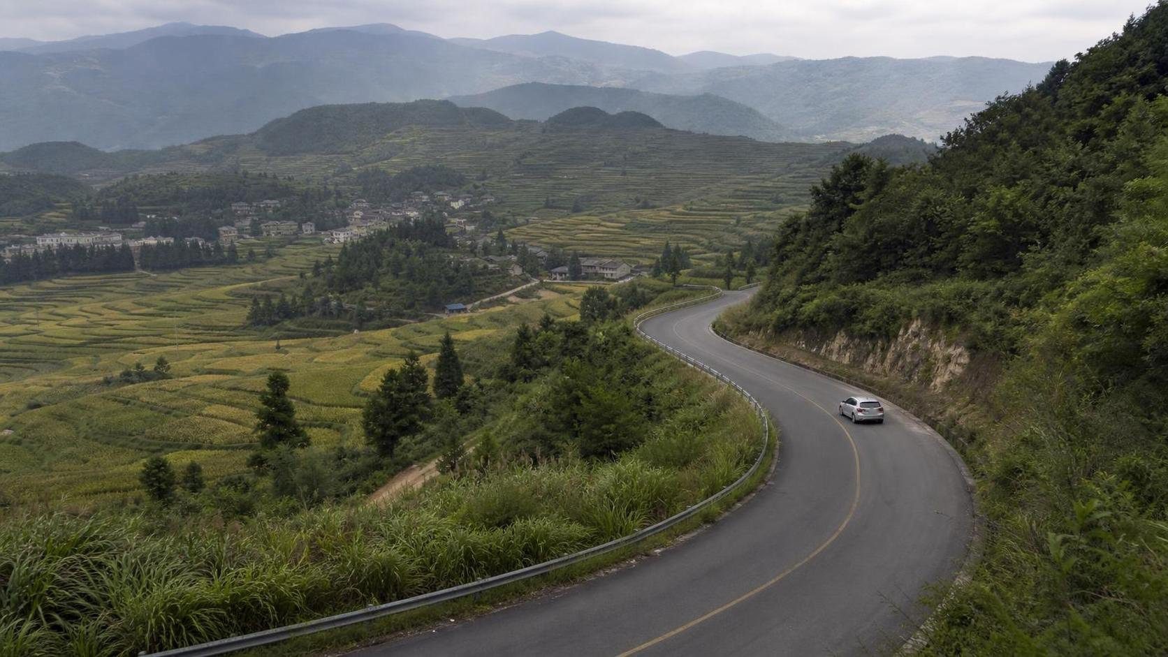 Unbranded compact car on a rural mountain road during a regional trip in China